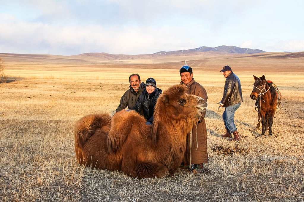 Kristin and Xavier meeting camels on a couple travel sabbatical in Mongolia