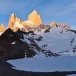 Mount Fitz shimmer orange at sunrise across Laguna de los Tres